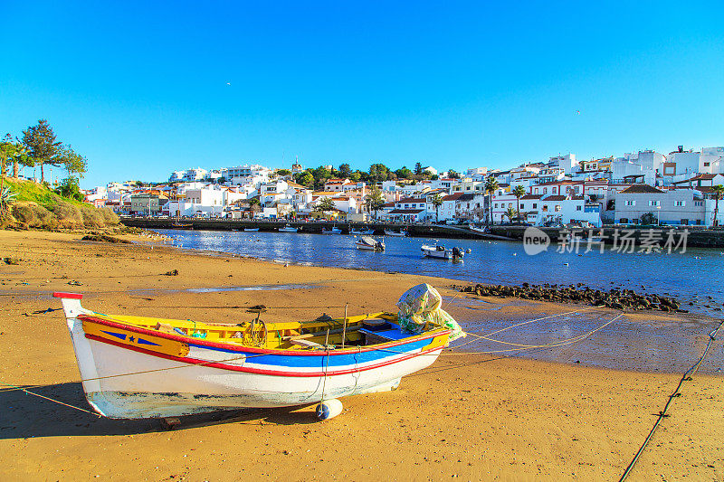 葡萄牙Portimao海滩上温暖的夕阳下的船只