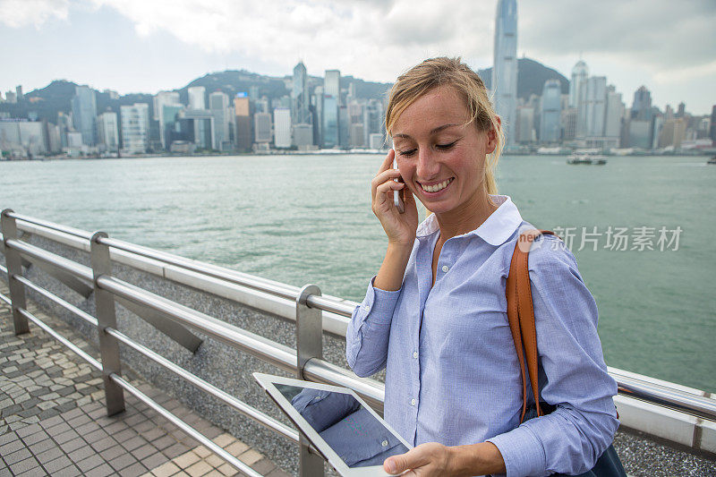 商业女性在电话中，使用数码平板电脑，香港