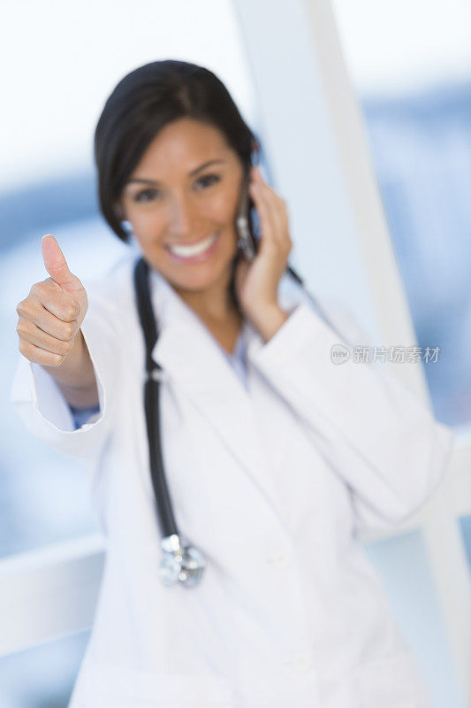 西班牙女医生竖起大拇指，手机