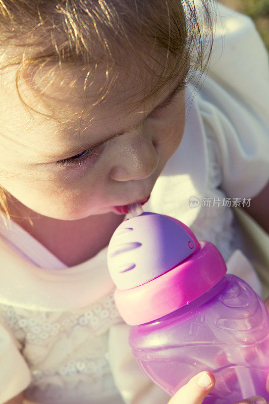 小女孩拿着奶瓶