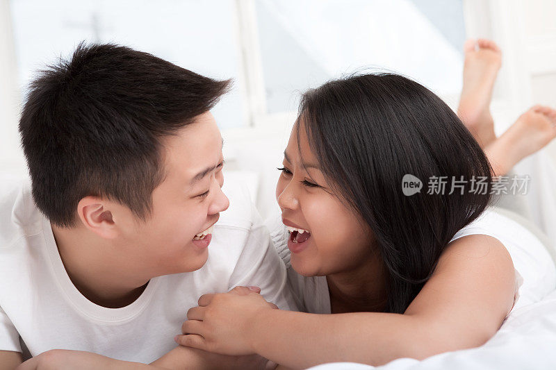 年轻幸福的亚洲夫妇卧室肖像