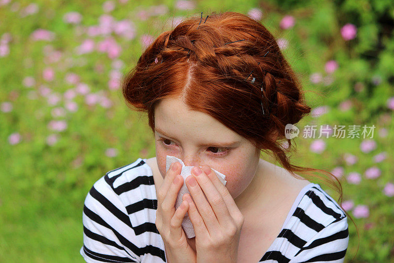 花园里的女孩得了花粉病，擤鼻涕，打喷嚏，过敏