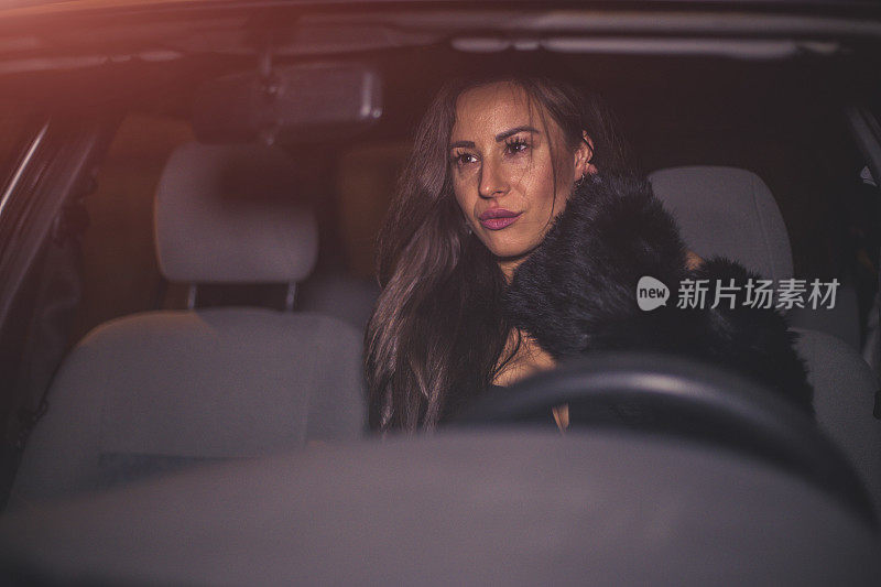 美丽的女人在晚上开车