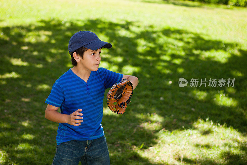 严肃的男孩打棒球时看向别处