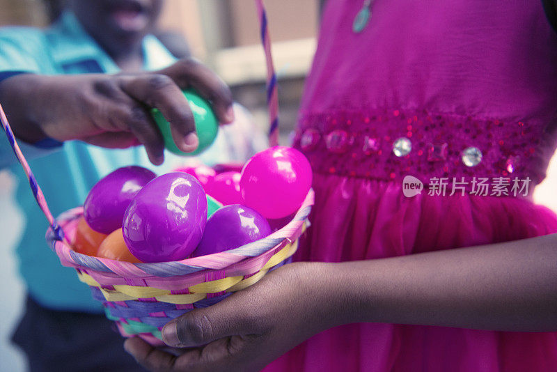 孩子们玩一篮子塑料复活节彩蛋