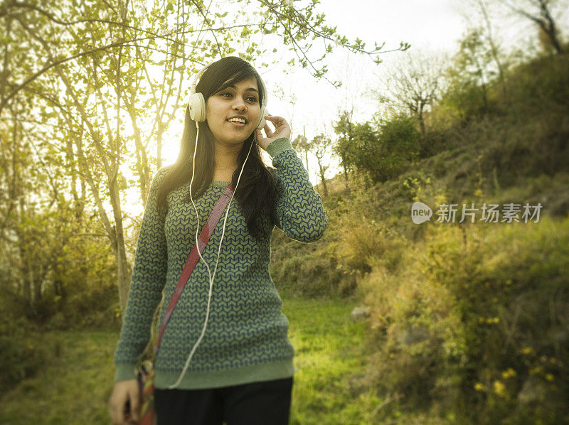 女孩独自站在公园里享受新鲜空气。