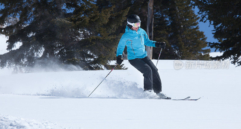 年轻女子在粉状雪中滑雪，科罗拉多州，美国。