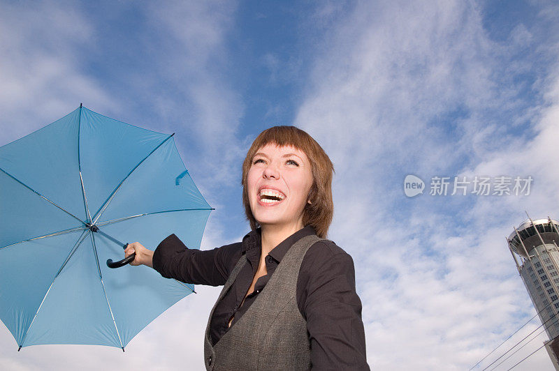 天空背景上带着伞微笑的女人