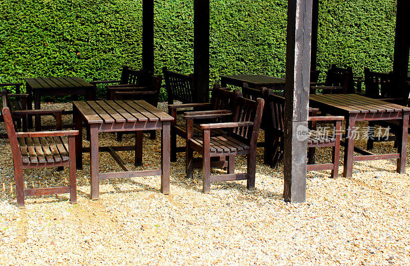 木制的花园桌子，椅子和长凳上的碎石