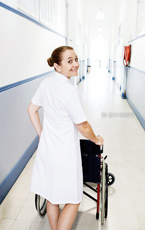 微笑的护士推着轮椅回头看她的肩膀
