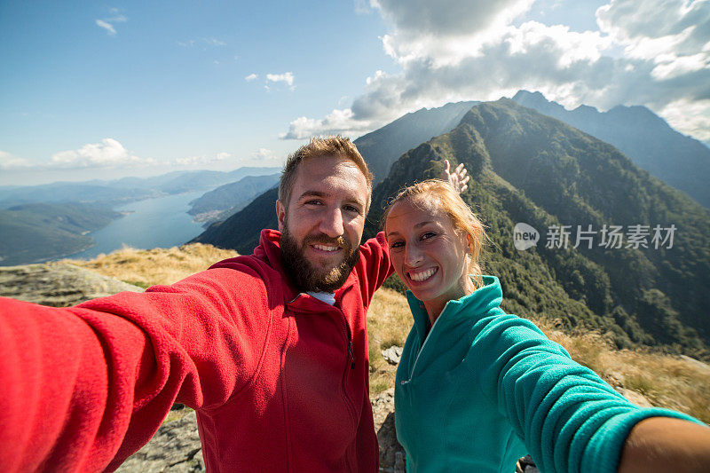 一对年轻夫妇在山顶徒步自拍