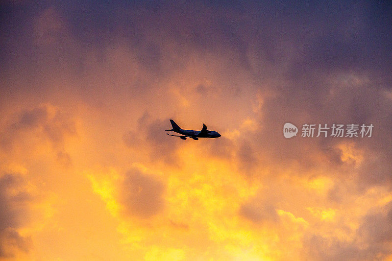 飞机飞过夕阳下的红云