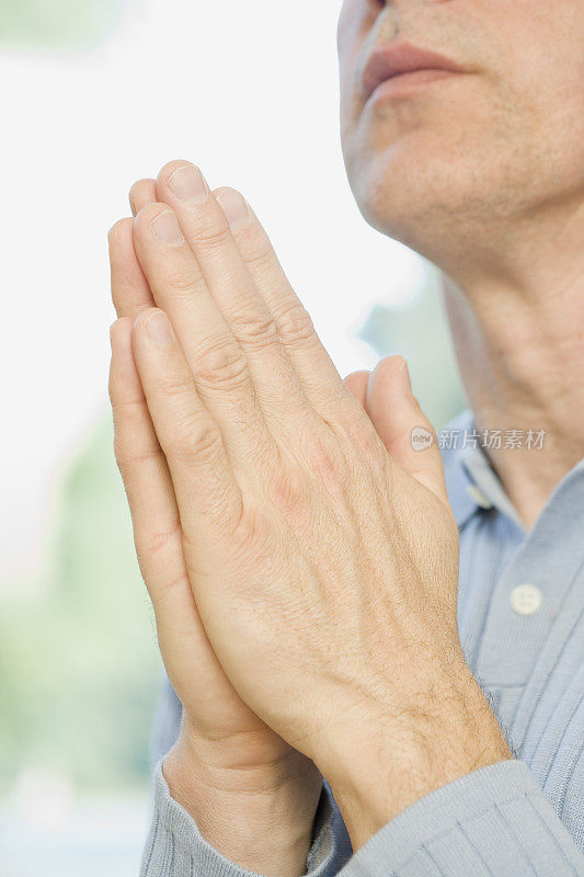 男人双手合十祈祷