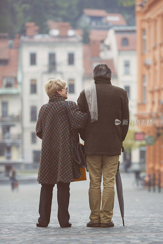 在欧洲街头漫步的老年游客夫妇