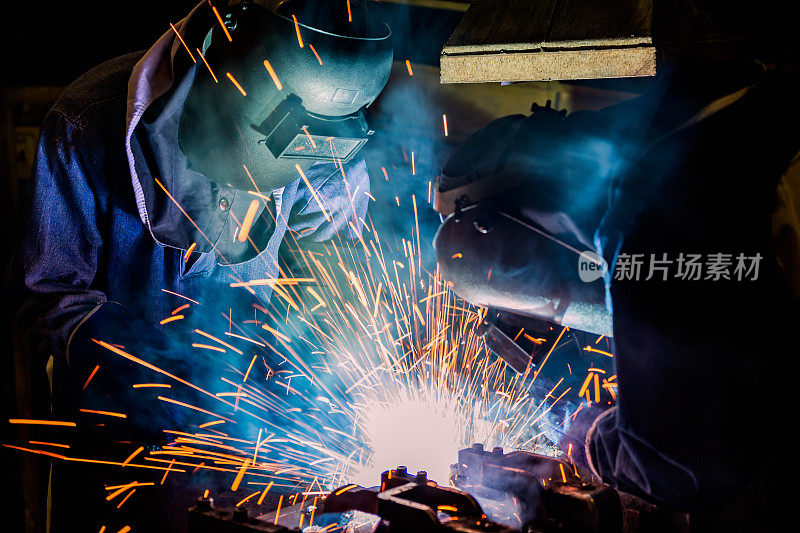 工业工人正在工厂里焊接装配的金属零件