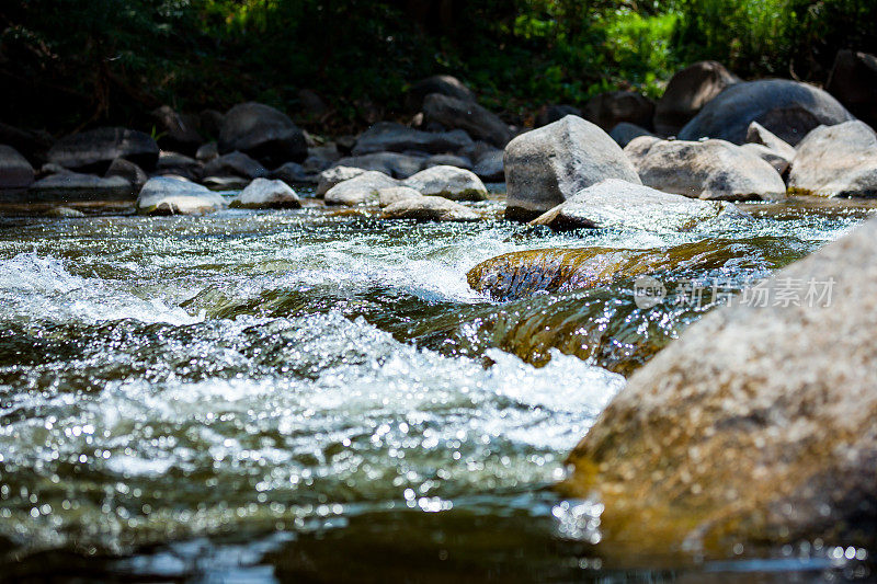 特写的石头与水在河上的急流，在旅游景点