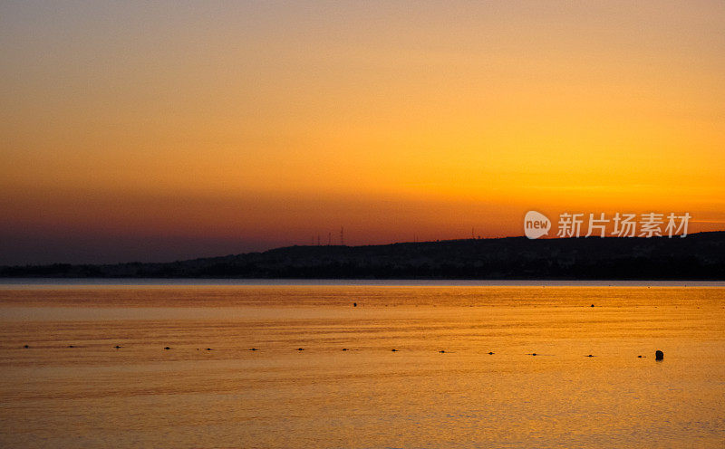 美丽的日落在突尼斯哈马迈特镇附近的海滩上。地中海。北非