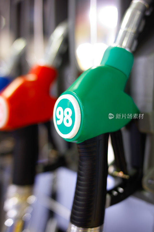 绿色和红色的燃料手枪在加油站。