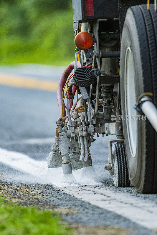 特写商业卡车重新油漆道路标记在农村道路。