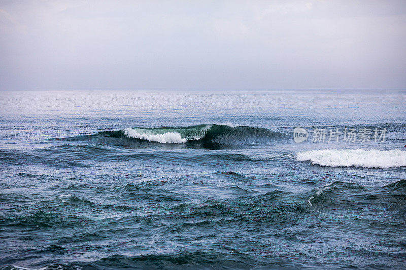 大海中蓝色的波浪。在巴厘岛破浪冲浪