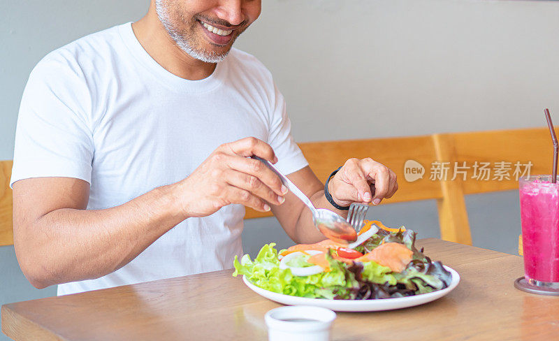 年轻快乐的男人享受着健康的饮食