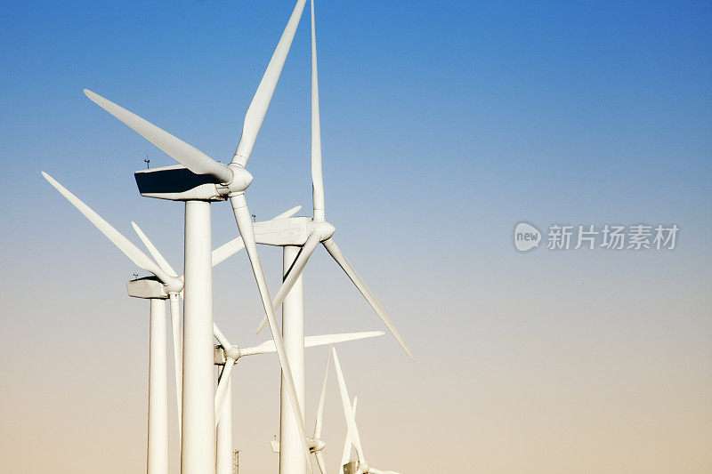 风力涡轮机，可持续能源，粉色和蓝色的天空背景。