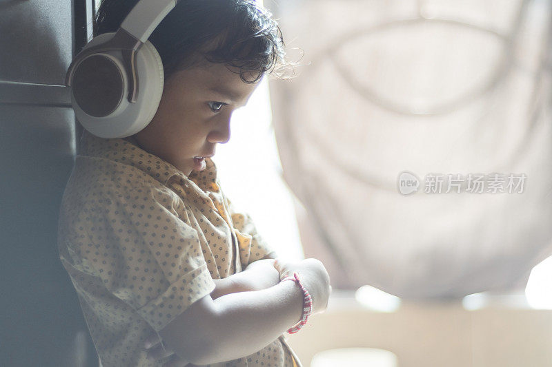 小男孩用耳机听音乐