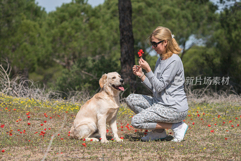 快乐的女人和她的狗一起摘花