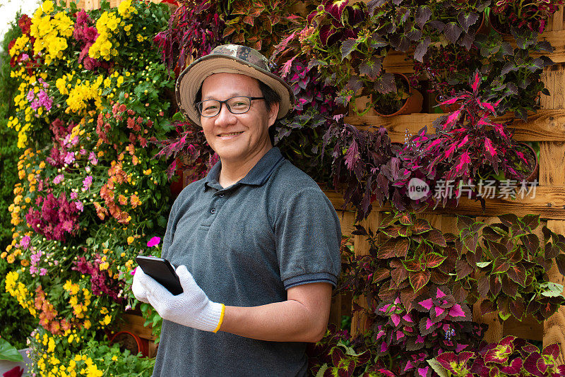 中年企业家微笑着，为自家后院盛开的鲜花而自豪