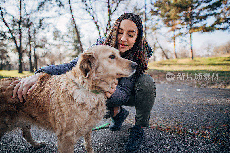 女孩和她的寻回犬玩耍