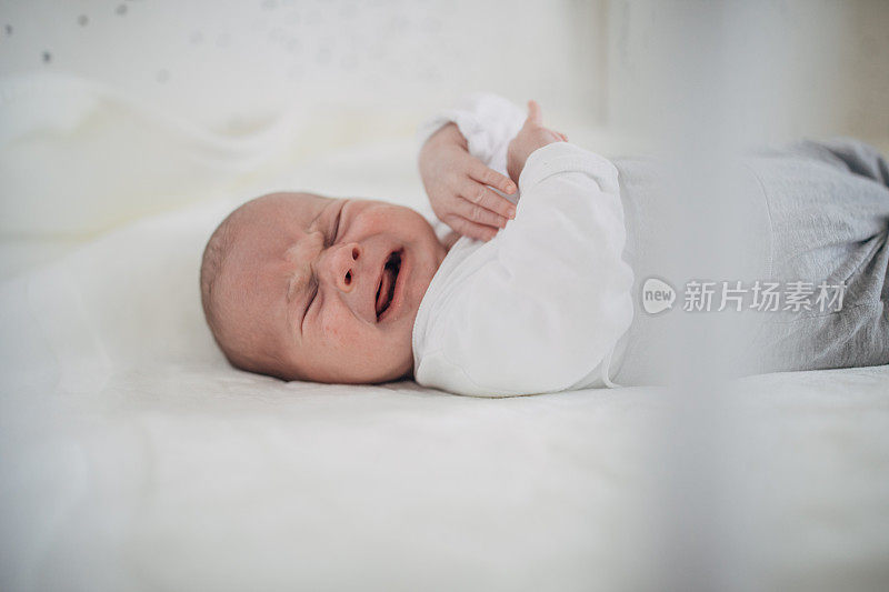 刚出生的男婴在婴儿床里哭