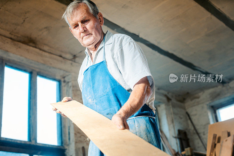 有经验的木匠检查木板是否刨平