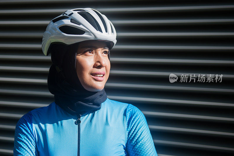 年轻的亚洲穆斯林妇女戴着头巾骑自行车的肖像