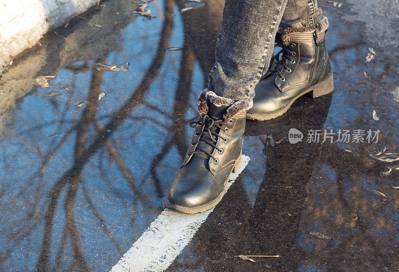 女人的脚在水坑里。鞋子，靴子，走，走。沥青、标记、污垢。秋天,泥浆,春天。关闭了。休闲