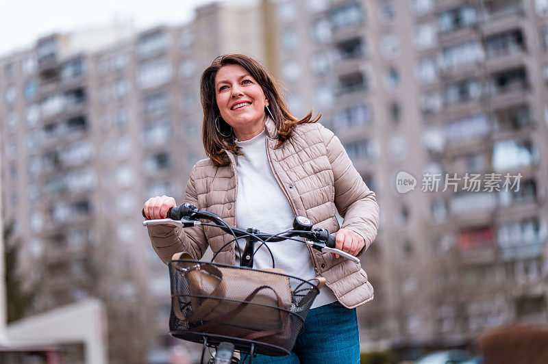 在住宅区里骑着自行车走路的妇女