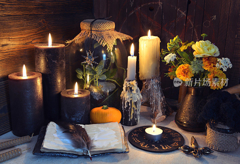 神秘的静物与打开的日记本和黑蜡烛在女巫的桌子上
