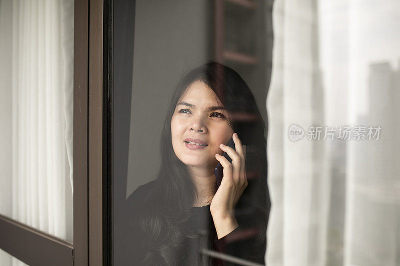 一个中国女人在她的公寓里使用电话