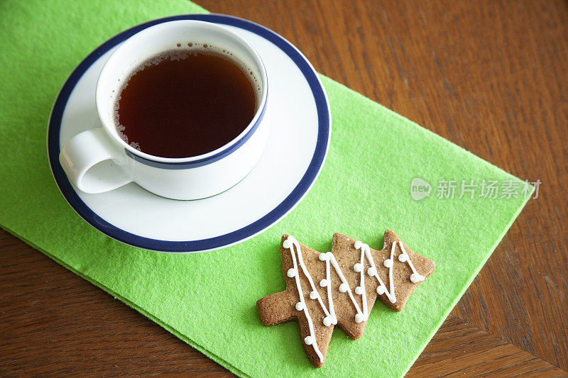 木桌上放着一杯装有圣诞装饰品的茶