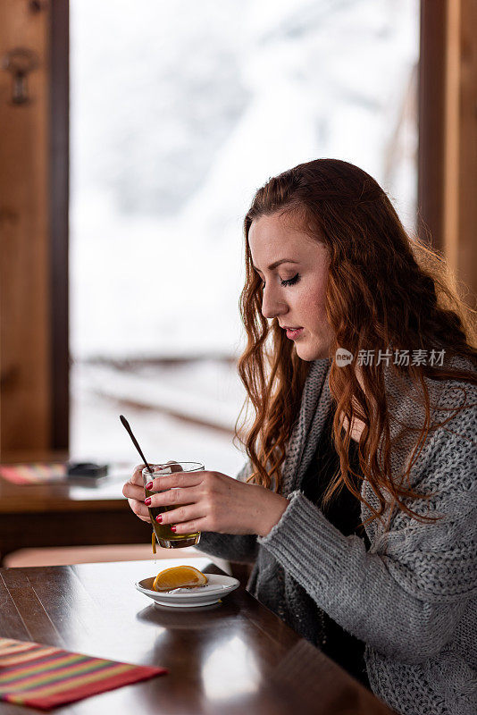 漂亮的年轻女人在咖啡馆喝茶存货照片