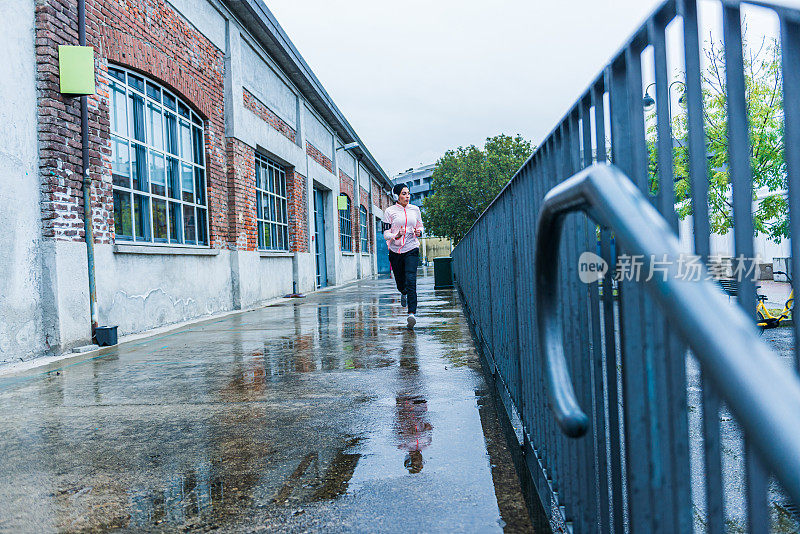 年轻的穆斯林妇女跑过城市