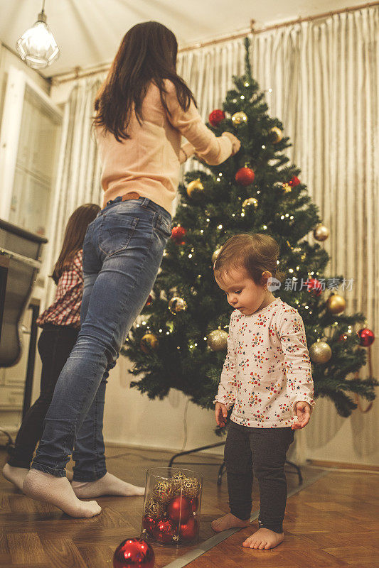 小女孩在帮忙装饰圣诞树