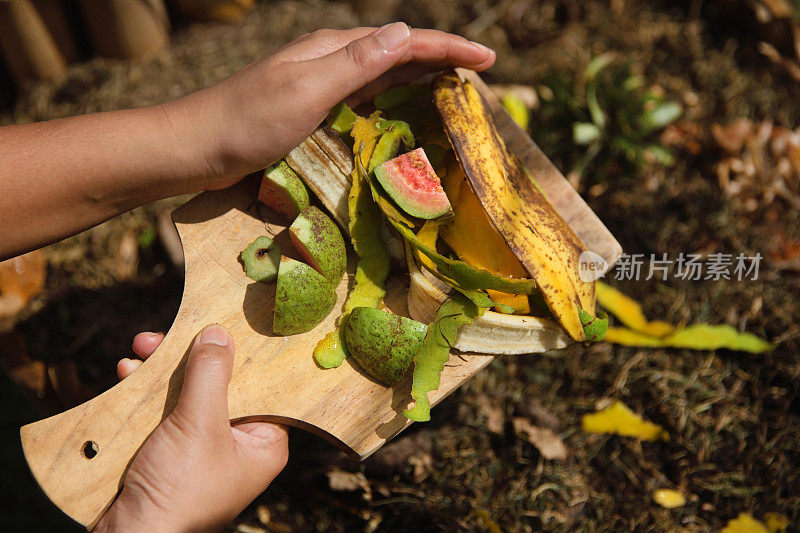 一个面目全非的女人往堆肥堆里扔食物残渣