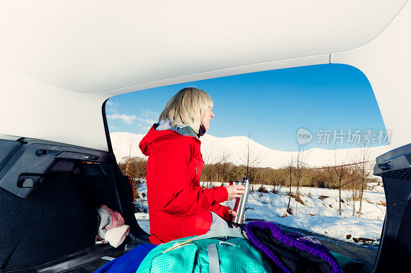 老妇人准备在苏格兰高地雪地里徒步旅行