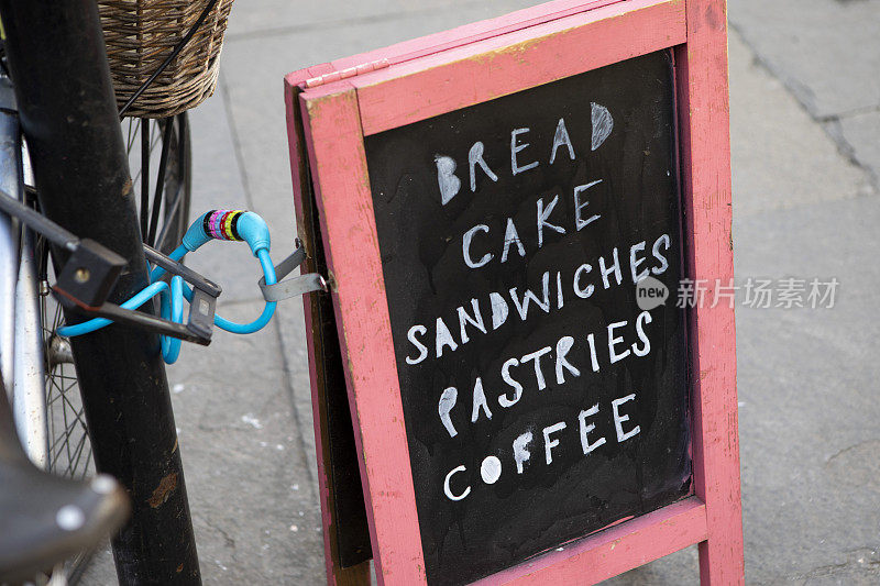 为咖啡店和面包店做广告的a型小招牌，用自行车拴在柱子上