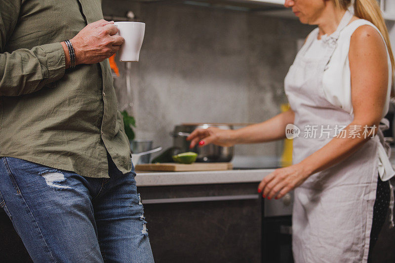 当他的妻子在准备午餐时，他正在享受一杯咖啡