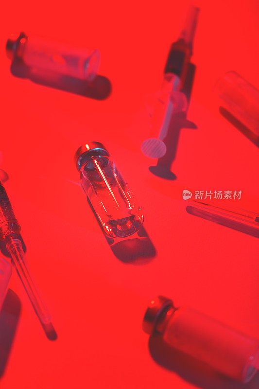 装有疫苗和红色注射器的医用瓶