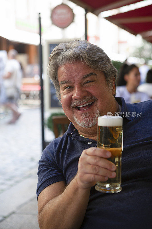 男子拿着一杯啤酒对镜头微笑