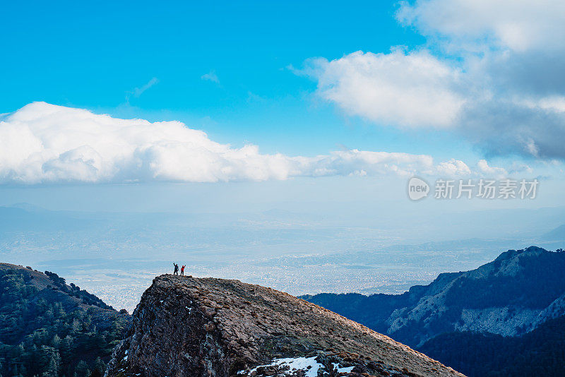 无人机拍摄的成功登山队在山顶竖起大拇指。