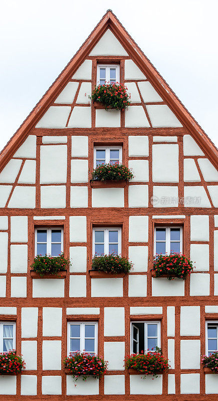 在德国巴伐利亚州施瓦巴赫，一栋带有红色横梁和白色窗户的半木房子