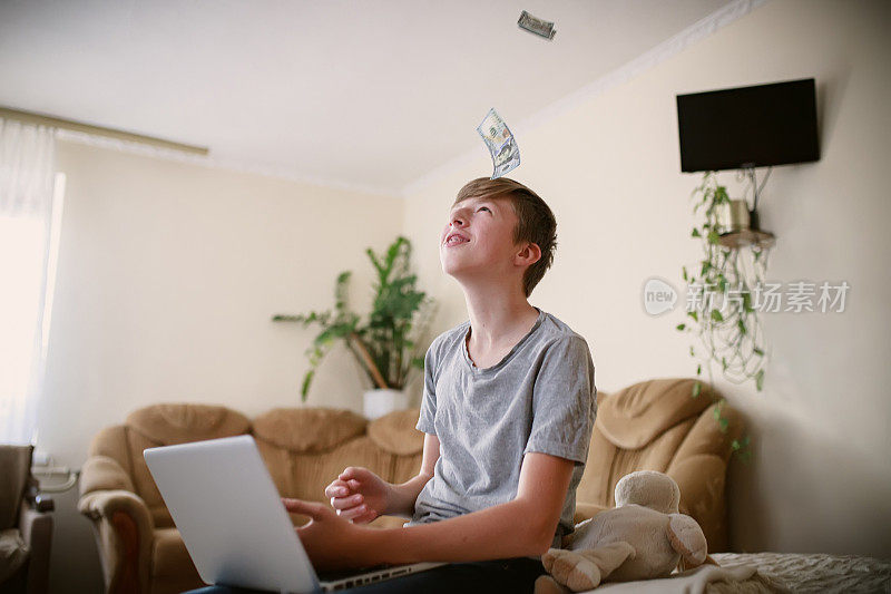 十几岁的自由职业者在笔记本电脑上计算着网上挣来的钱，对收入很满意。男孩在网上学习，在家舒舒服服地赚钱。孩子在电话会议上数钱给朋友看。